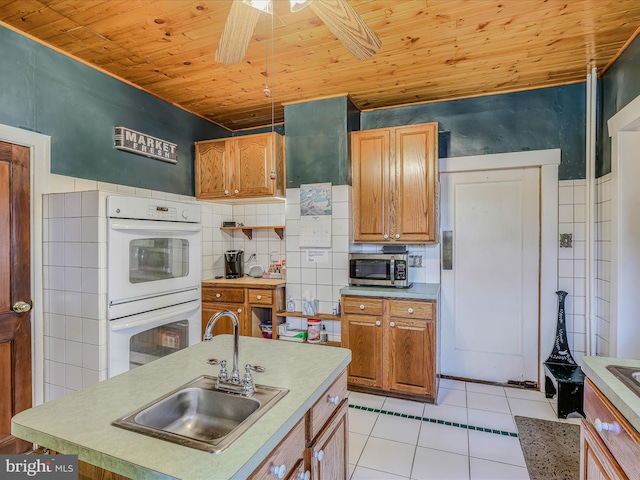 kitchen with sink, wood ceiling, light tile patterned floors, ceiling fan, and double oven