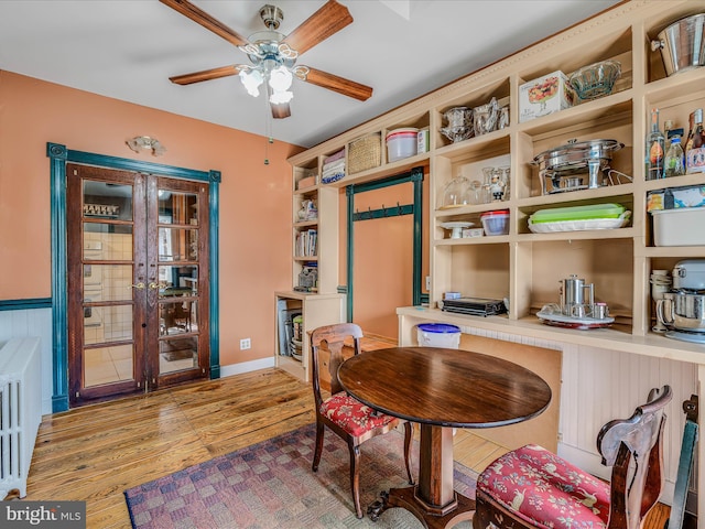 sitting room with french doors, ceiling fan, and light wood-type flooring