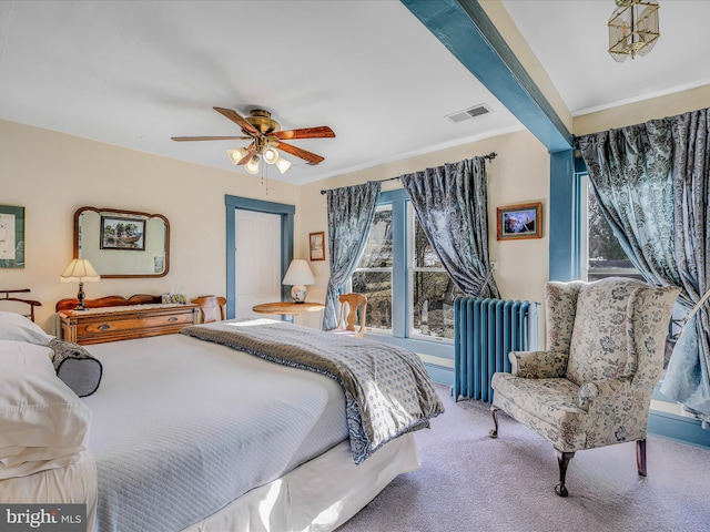 carpeted bedroom with ceiling fan and radiator heating unit