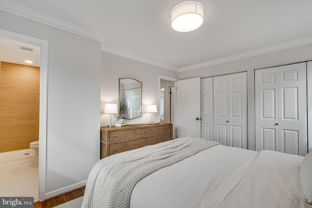 bedroom with multiple closets, ensuite bath, crown molding, and light hardwood / wood-style floors