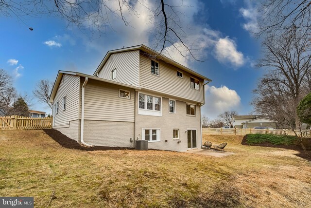 rear view of property with central AC unit, a yard, and a patio