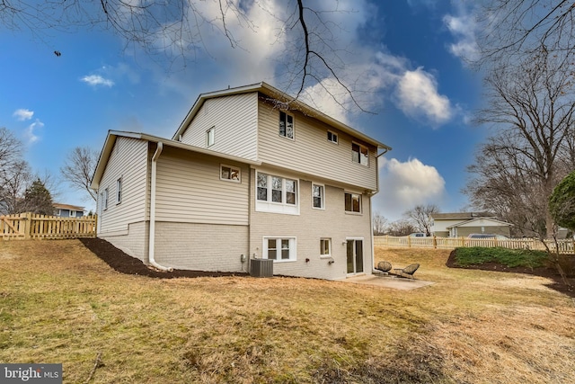 rear view of house featuring cooling unit, a patio area, and a lawn