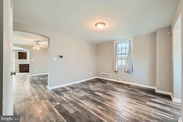 spare room featuring dark wood-type flooring and ceiling fan