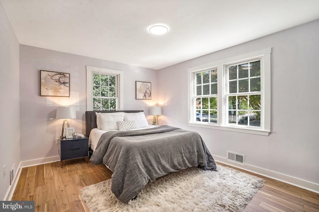 bedroom featuring light hardwood / wood-style floors and multiple windows