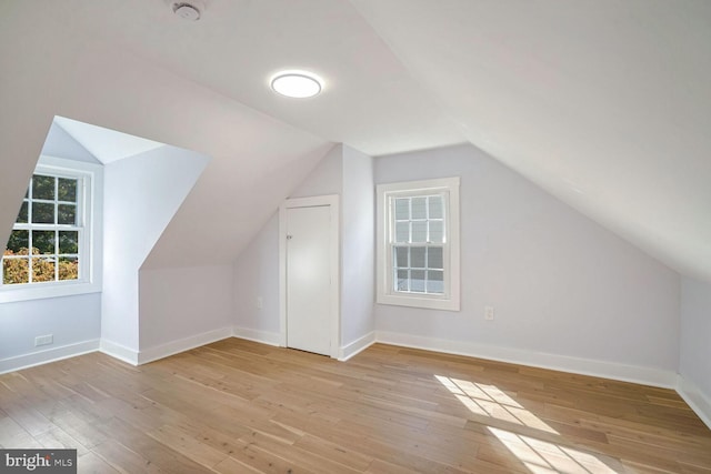 bonus room with vaulted ceiling and light hardwood / wood-style flooring