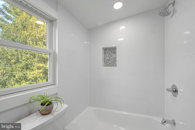 bathroom featuring tiled shower / bath