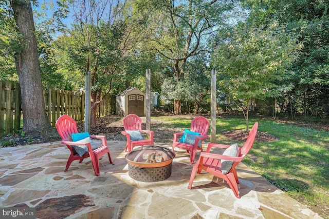 view of patio featuring a storage unit and an outdoor fire pit