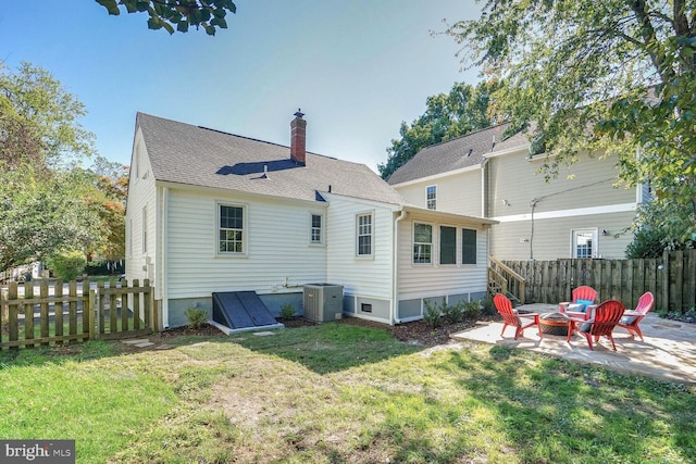 back of house with cooling unit, a patio area, a fire pit, and a lawn