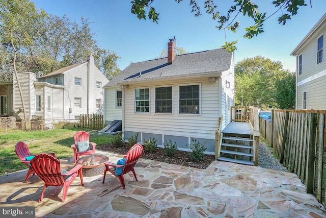 back of property with a patio and a fire pit