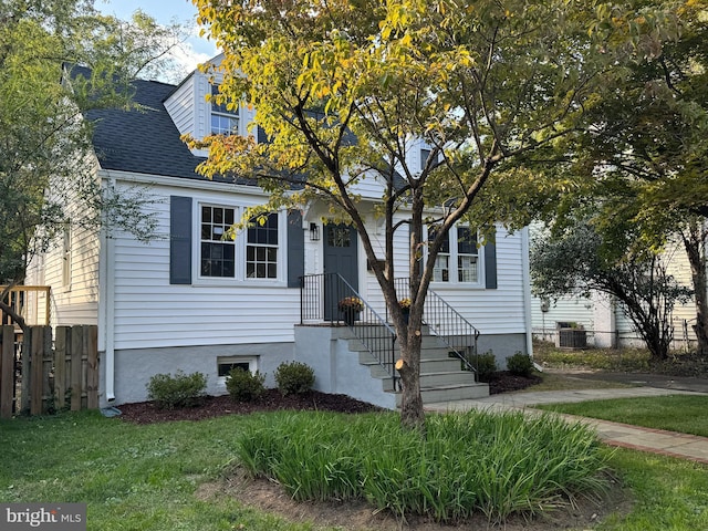 view of front of house with a front lawn and central air condition unit