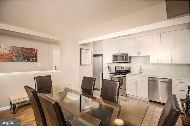 dining room featuring sink and light wood-type flooring