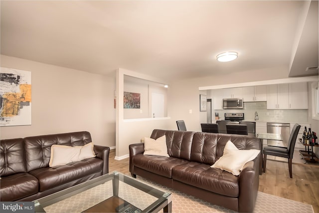 living room with sink and light hardwood / wood-style flooring