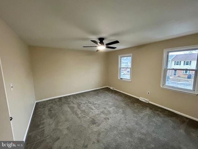 carpeted spare room featuring ceiling fan