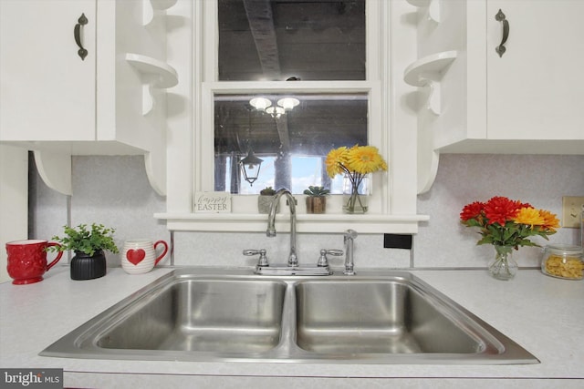 interior details with white cabinetry and sink