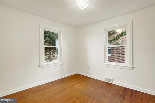 unfurnished room with hardwood / wood-style floors