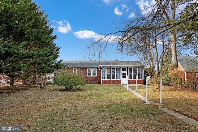 view of front of home with a sunroom and a front yard