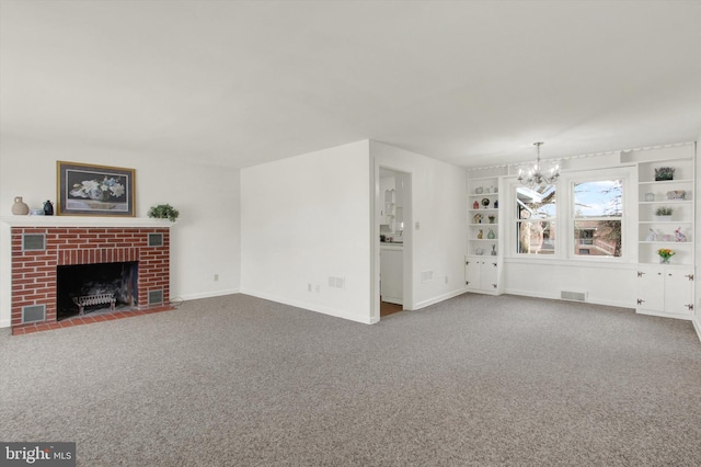 unfurnished living room featuring a fireplace, a chandelier, and carpet