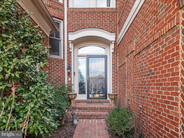 property entrance featuring brick siding