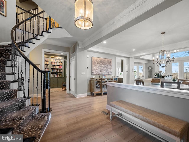 foyer entrance featuring beamed ceiling, hardwood / wood-style flooring, an inviting chandelier, baseboards, and stairs