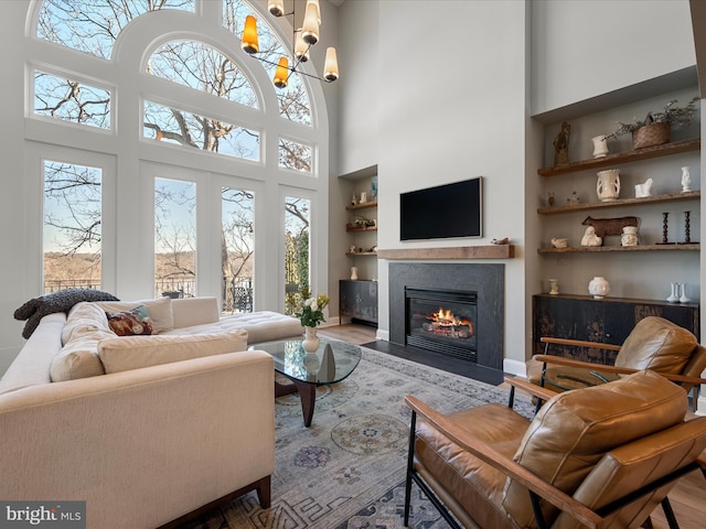 living area with a wealth of natural light, a fireplace with flush hearth, and built in shelves