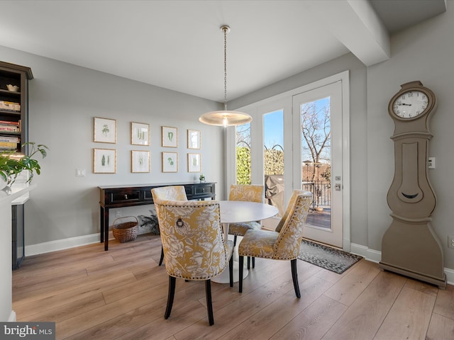 dining space with light wood finished floors and baseboards