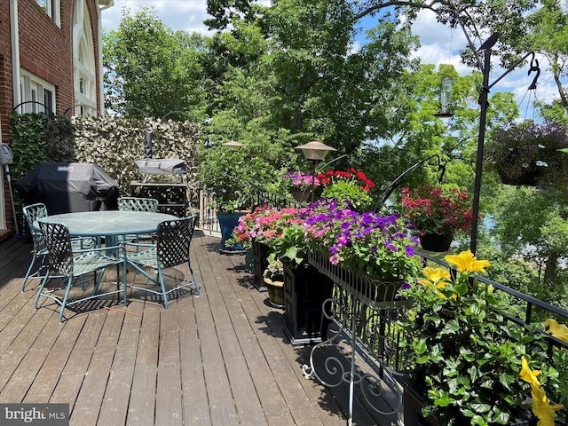 wooden deck with outdoor dining area and a grill