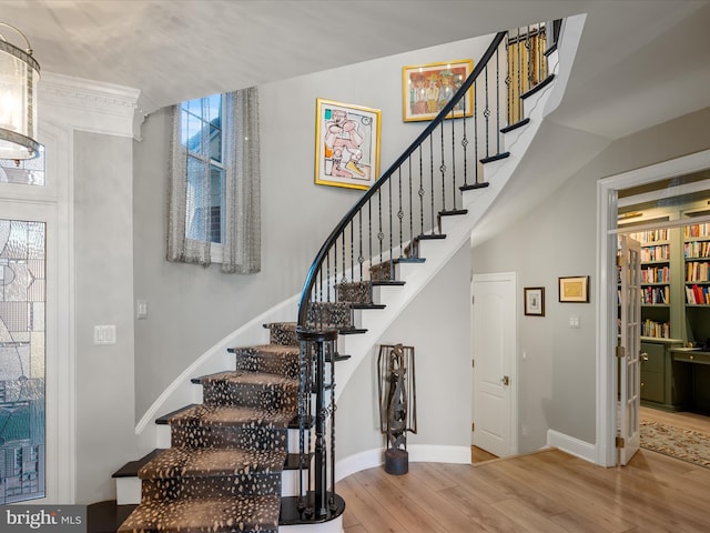 staircase featuring wood finished floors and baseboards