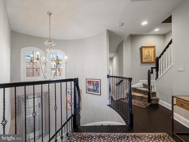 staircase featuring visible vents, baseboards, recessed lighting, an inviting chandelier, and wood finished floors