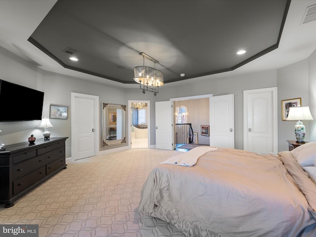 bedroom with a raised ceiling, recessed lighting, and visible vents