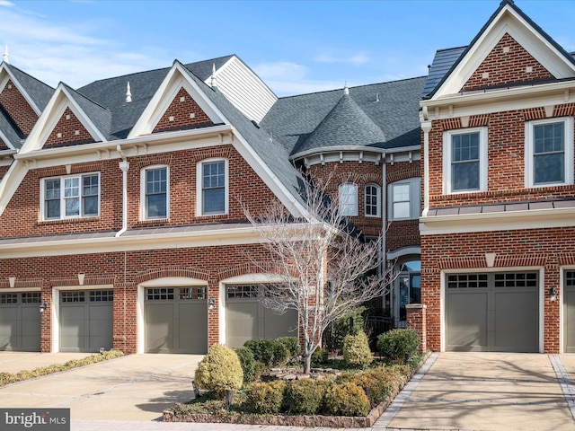 view of property featuring an attached garage, brick siding, and driveway