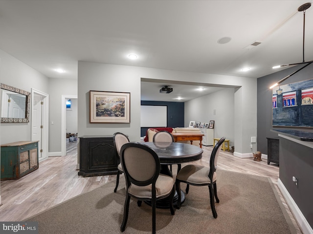 dining area with visible vents, baseboards, and light wood-style floors