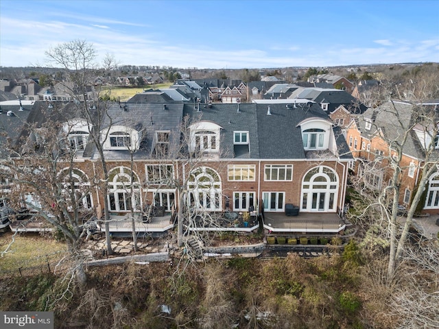 rear view of property featuring brick siding, french doors, and a residential view