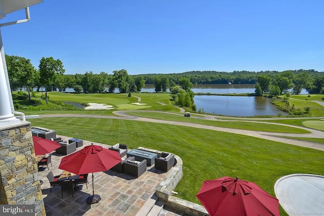 view of yard featuring a patio area, golf course view, a fire pit, and a water view