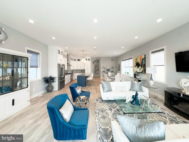 living room featuring an inviting chandelier and light hardwood / wood-style floors