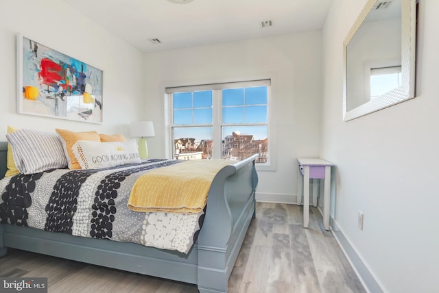 bedroom with hardwood / wood-style floors and multiple windows