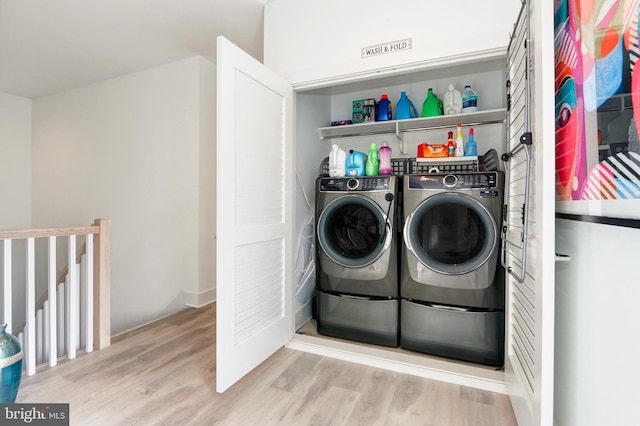 laundry room with light hardwood / wood-style floors and washing machine and clothes dryer