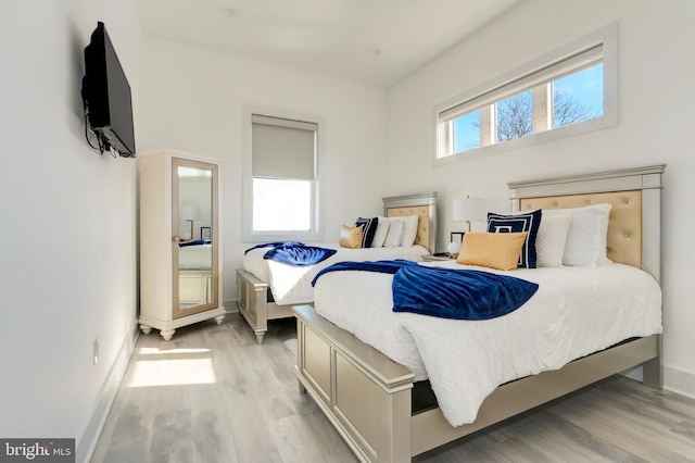 bedroom with multiple windows and light hardwood / wood-style floors