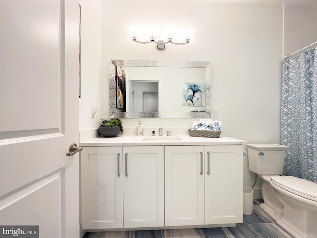 bathroom with vanity, toilet, and curtained shower