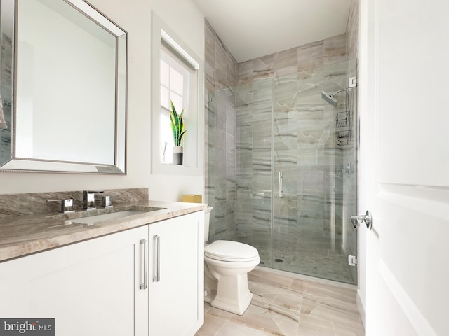 bathroom featuring vanity, an enclosed shower, and toilet