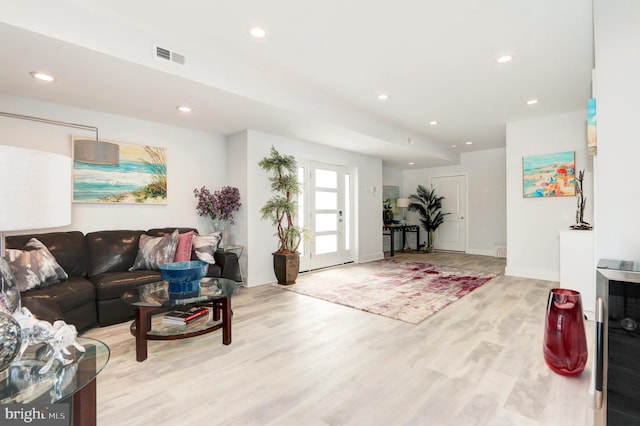 living room featuring wine cooler and light hardwood / wood-style flooring