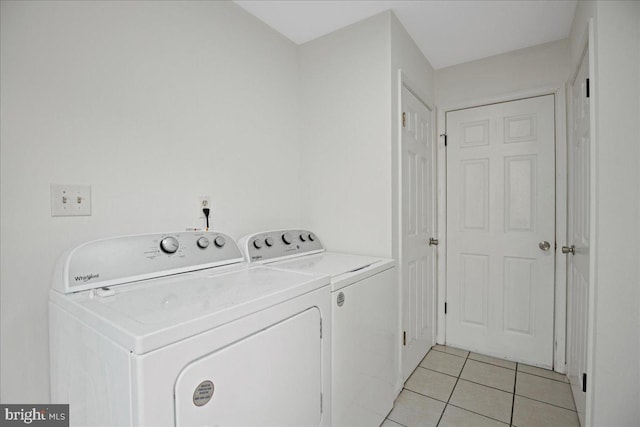 laundry room with light tile patterned floors and washing machine and dryer