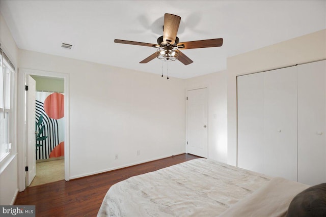 bedroom with dark hardwood / wood-style flooring, a closet, and ceiling fan