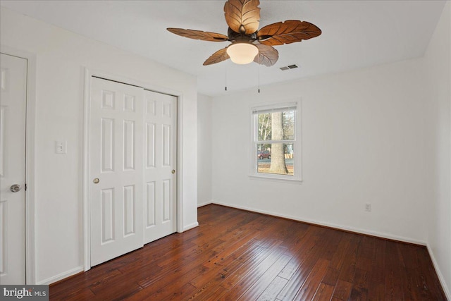 unfurnished bedroom with ceiling fan, dark hardwood / wood-style flooring, and a closet