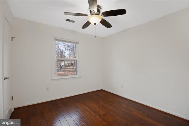 empty room featuring dark wood-type flooring and ceiling fan