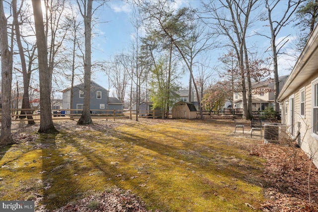 view of yard featuring central AC and a storage shed