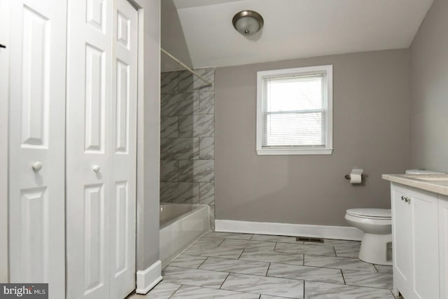 full bathroom featuring vanity, tiled shower / bath combo, and toilet