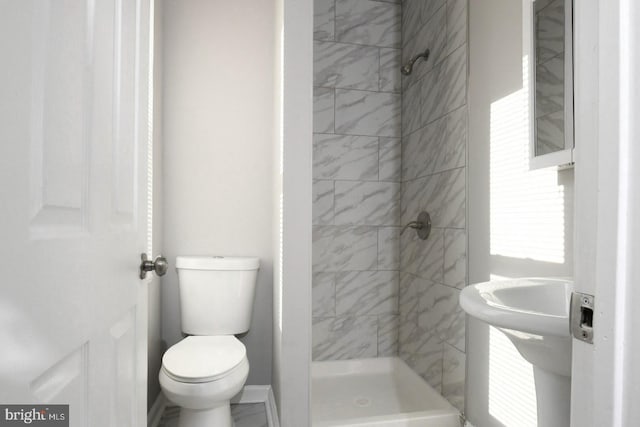 bathroom featuring toilet and tiled shower