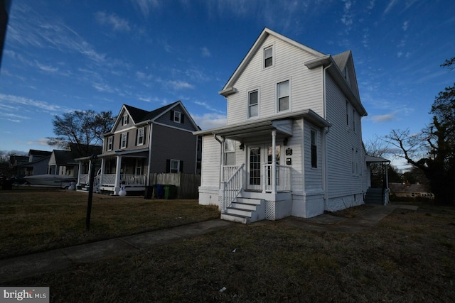 view of front facade with a front yard and covered porch