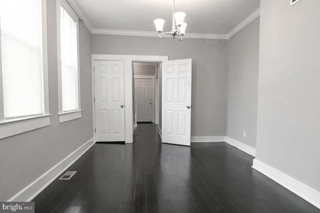 interior space with multiple windows, ornamental molding, a chandelier, and dark hardwood / wood-style flooring