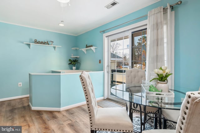 dining area featuring hardwood / wood-style flooring and ornamental molding